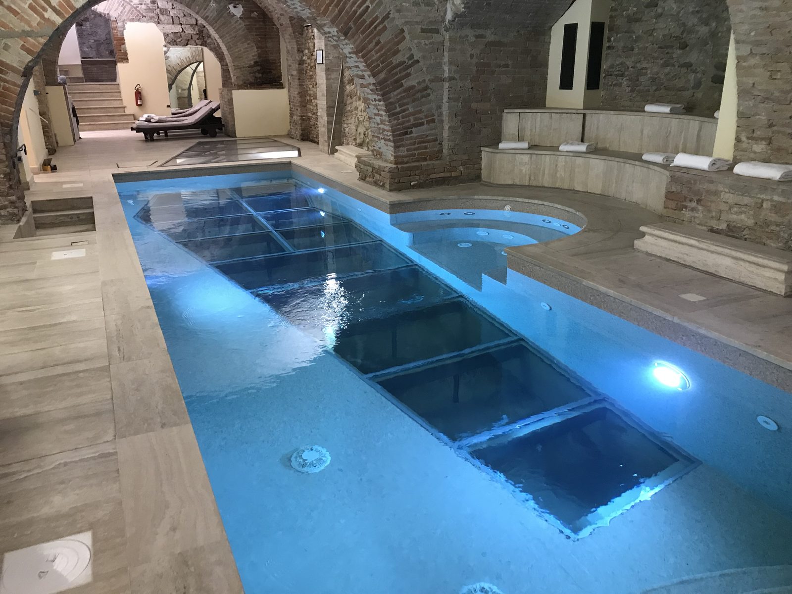 Piscina interna con pavimento in vetro illuminato nella spa dell’Hotel Brufani a Perugia