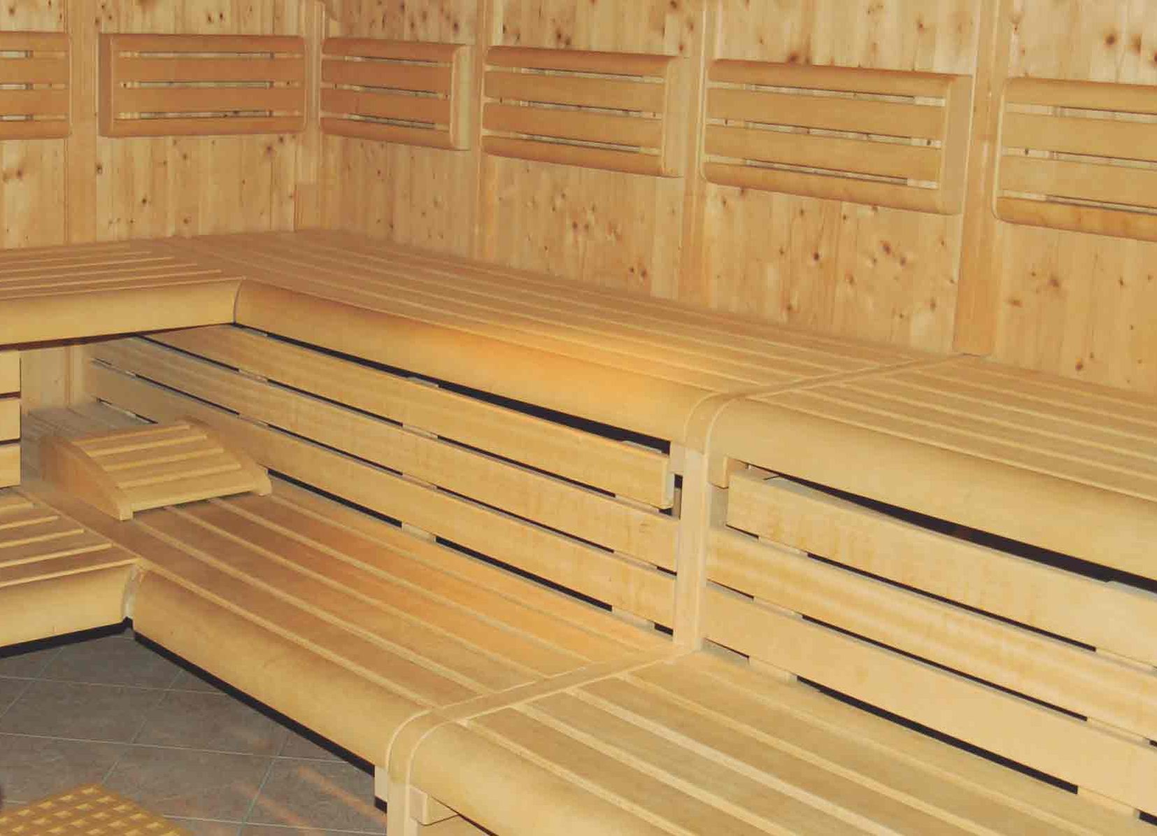Interno di una sauna finlandese con panche in legno chiaro su più livelli