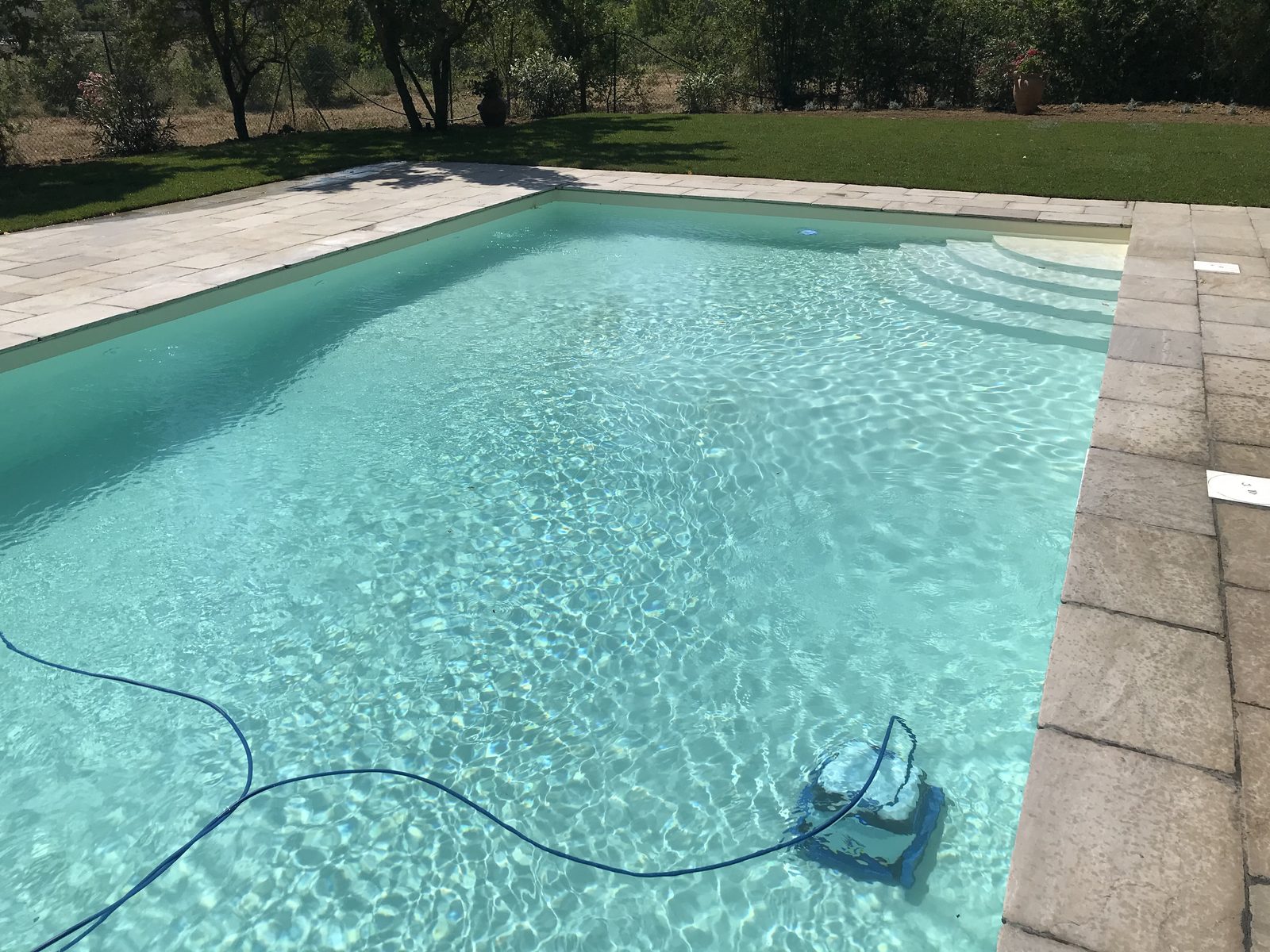 Robot pulitore al lavoro sul fondo di una piscina