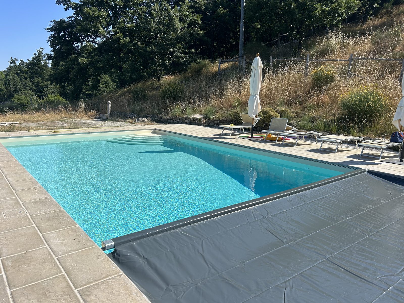 Piscina con la copertura invernale in parte stesa sulla vasca