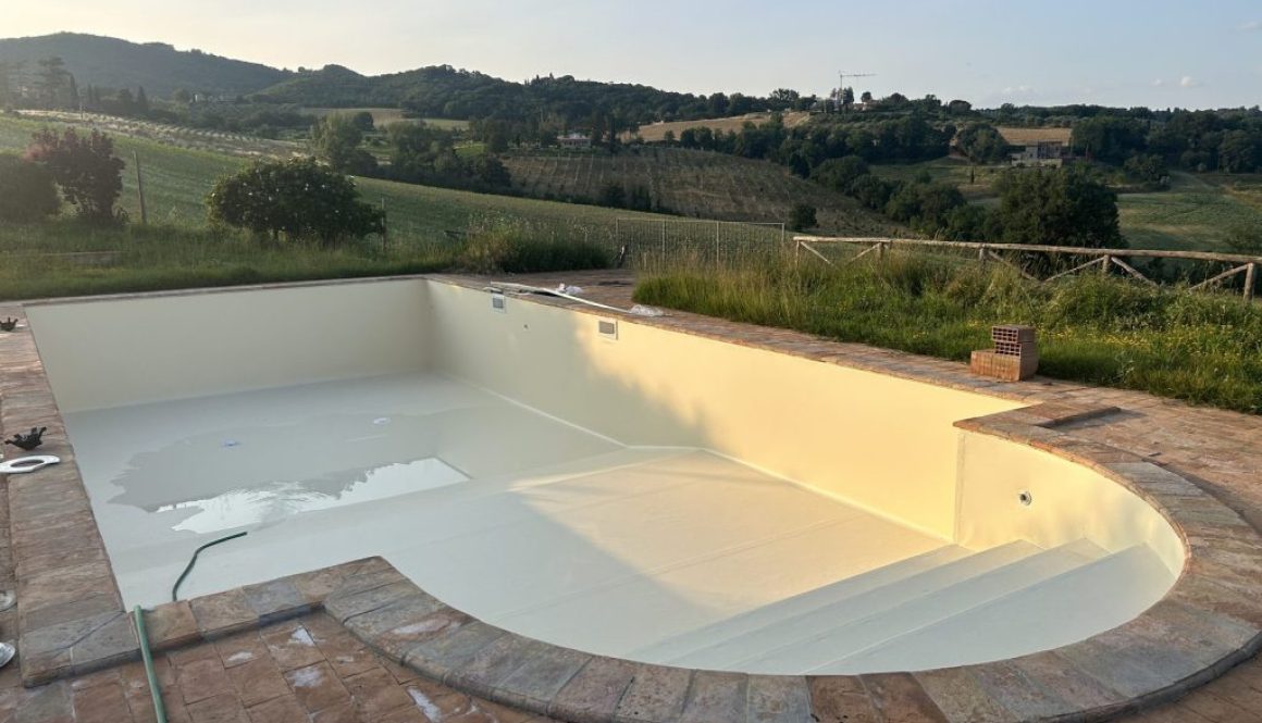 Piscina in costruzione con il nuovo rivestimento, tra le colline