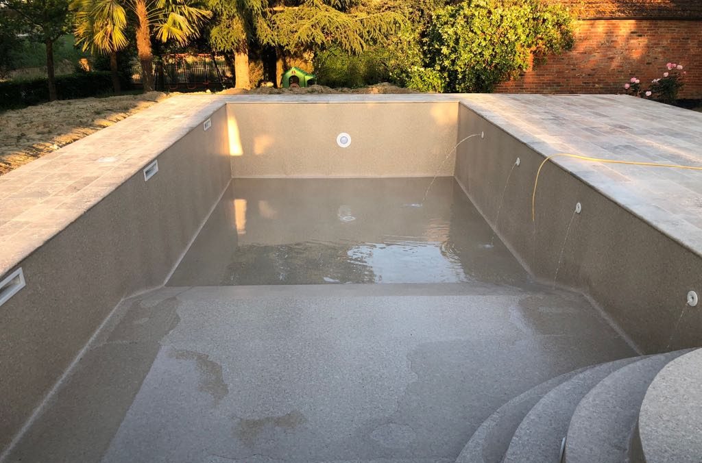 Piscina in ristrutturazione con il nuovo rivestimento color sabbia