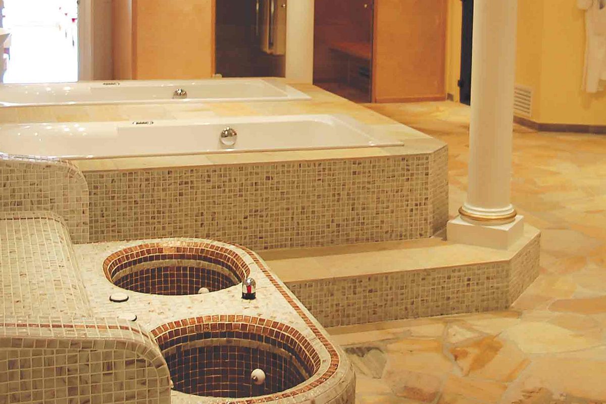 Vasche idromassaggio in mosaico e colonne nella spa del resort Villa Fiorita